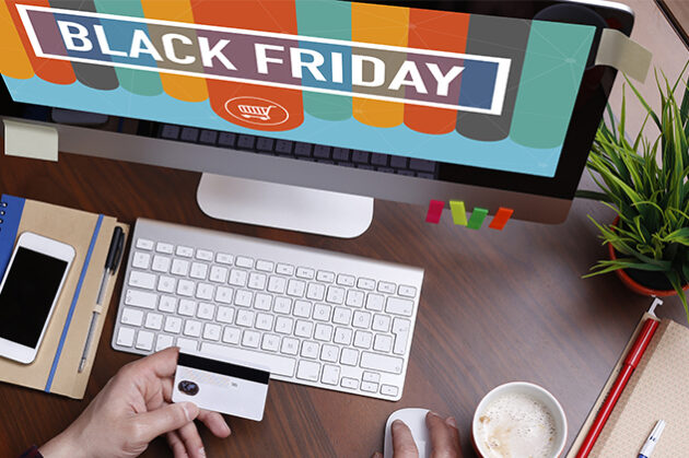 Άτομο που κάνει online αγορές κατά τη διάρκεια προσφορών Black Friday χρησιμοποιώντας έναν επιτραπέζιο υπολογιστή. Στην οθόνη εμφανίζεται το μήνυμα 'Black Friday' με έντονα χρώματα και ένα εικονίδιο καλαθιού αγορών. Το άτομο κρατάει μια πιστωτική κάρτα στο ένα χέρι, ενώ χρησιμοποιεί το ποντίκι για την πλοήγηση, έτοιμο να ολοκληρώσει μια αγορά. Ο χώρος εργασίας περιλαμβάνει πληκτρολόγιο, σημειωματάριο με στυλό, smartphone, μια κούπα καφέ και ένα γλαστράκι, δημιουργώντας ένα μοντέρνο και οργανωμένο περιβάλλον γραφείου